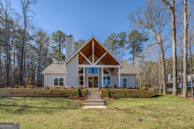 view of front of property with french doors, board and batten siding, a front yard, a shingled roof, and a chimney