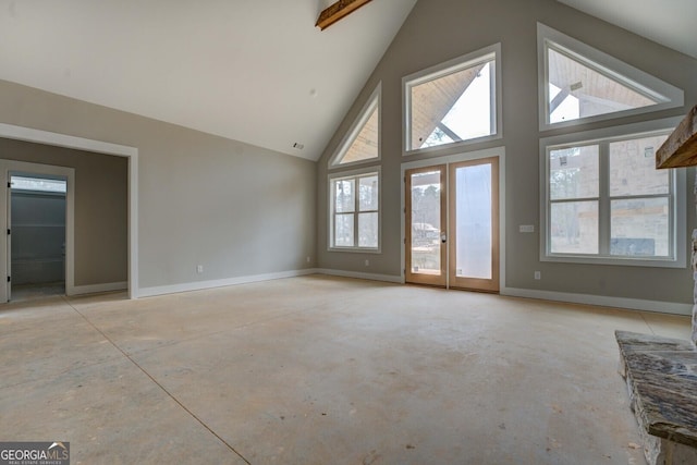 unfurnished living room featuring french doors, baseboards, high vaulted ceiling, and concrete flooring