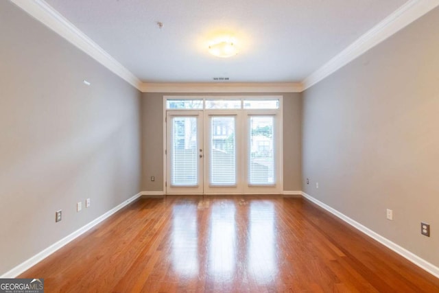 empty room featuring light hardwood / wood-style flooring and ornamental molding