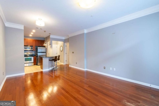 unfurnished living room with crown molding and light wood-type flooring