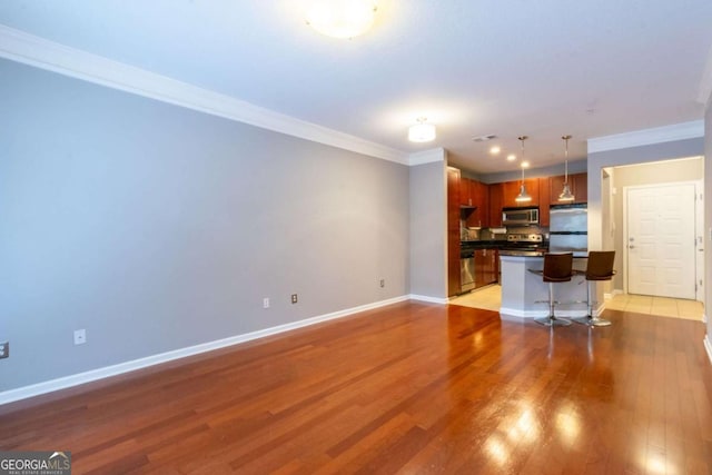 unfurnished living room featuring crown molding and hardwood / wood-style floors