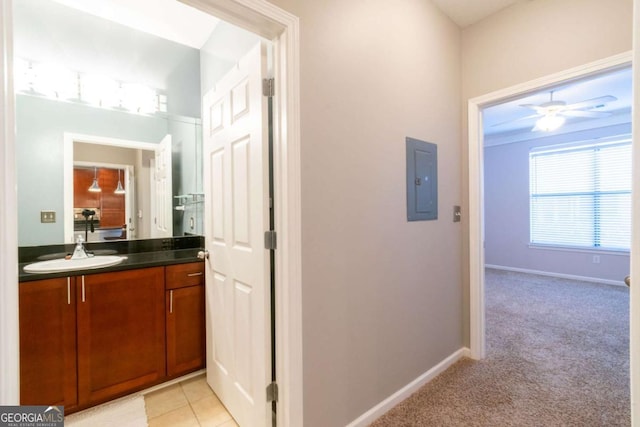 corridor featuring sink, light colored carpet, and electric panel