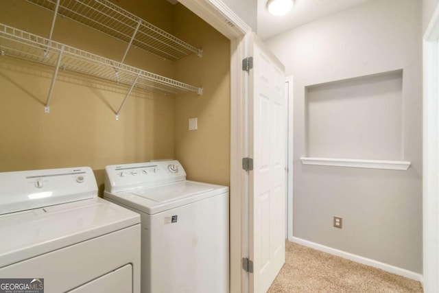 laundry room with independent washer and dryer and light colored carpet