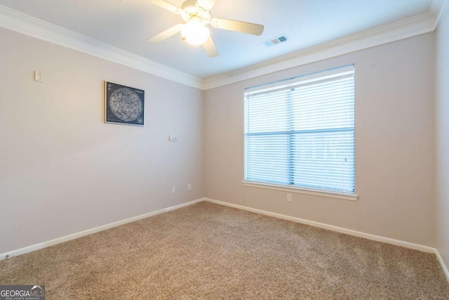 empty room featuring ceiling fan, ornamental molding, and carpet