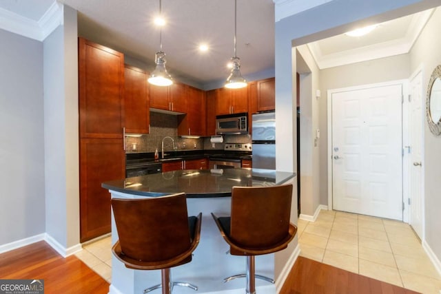 kitchen with a kitchen island, decorative light fixtures, sink, a kitchen bar, and stainless steel appliances