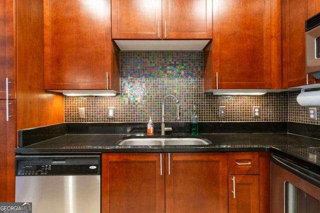 kitchen featuring stainless steel appliances, sink, dark stone countertops, and decorative backsplash