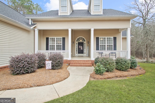 property entrance featuring a yard and covered porch