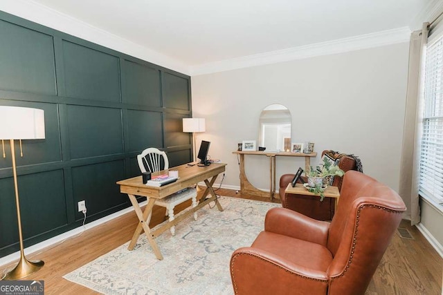 office space featuring ornamental molding, plenty of natural light, and light wood-type flooring