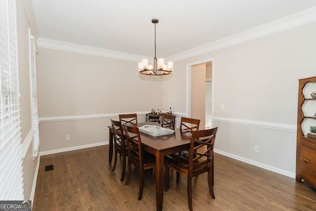 dining area with ornamental molding, dark hardwood / wood-style floors, and a chandelier