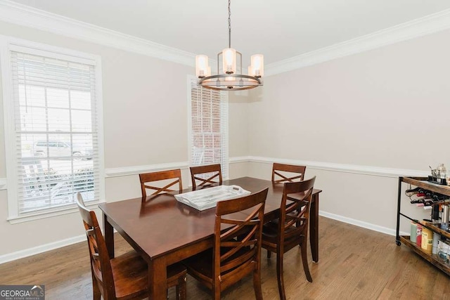 dining space featuring a notable chandelier, crown molding, and wood-type flooring