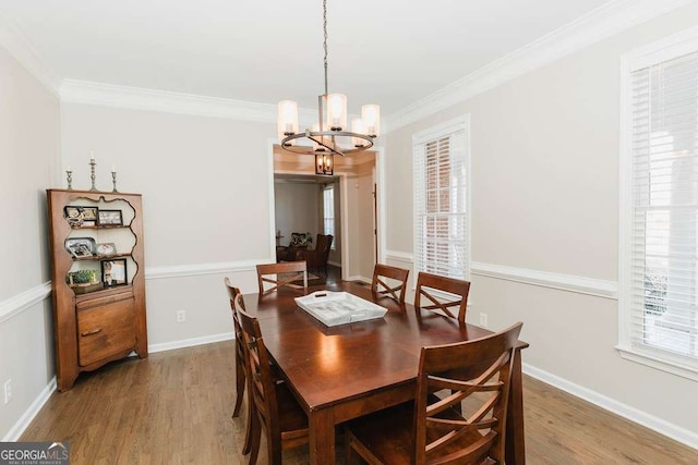 dining room featuring ornamental molding, hardwood / wood-style floors, and a chandelier