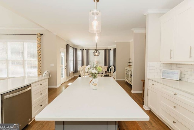 kitchen with pendant lighting, white cabinets, stainless steel dishwasher, and a spacious island