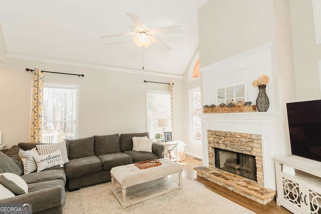 living room with hardwood / wood-style floors, a fireplace, lofted ceiling, ceiling fan, and crown molding