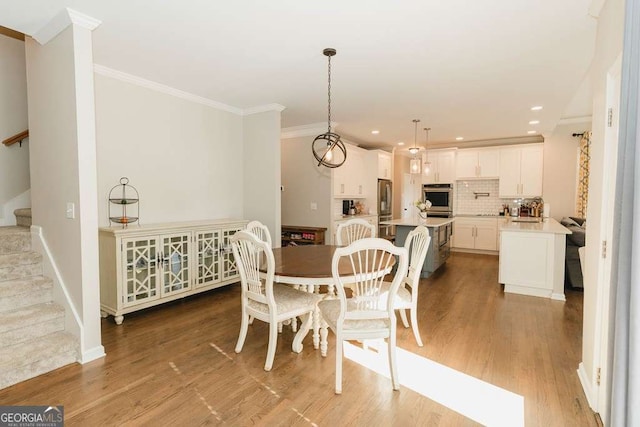 dining space featuring ornamental molding and hardwood / wood-style floors