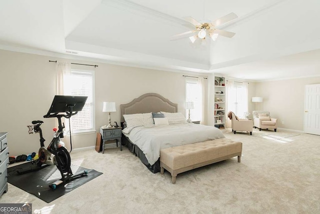 bedroom with light carpet, crown molding, a raised ceiling, and ceiling fan