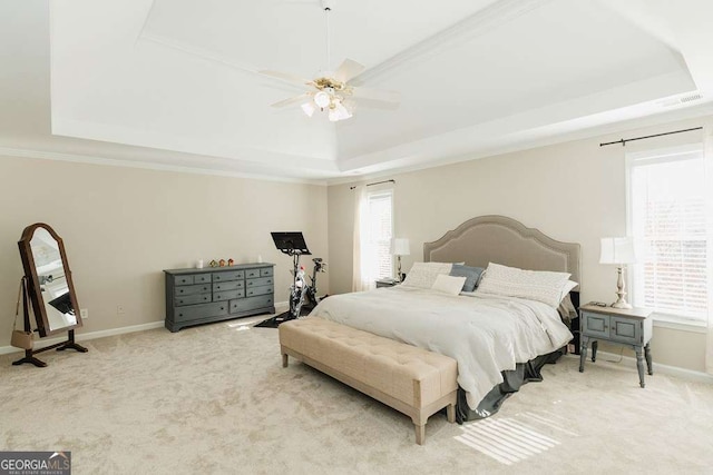 carpeted bedroom featuring ornamental molding, ceiling fan, and a tray ceiling