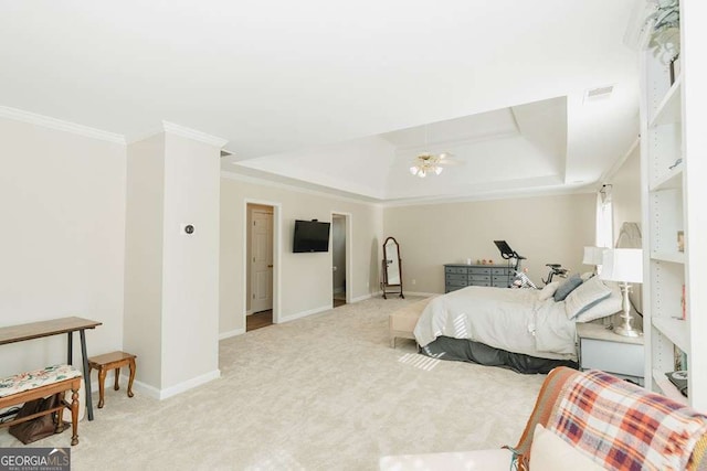 carpeted bedroom with ornamental molding and a tray ceiling