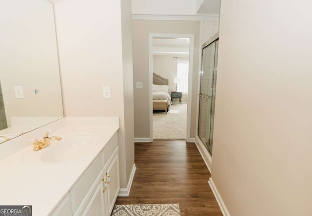 bathroom featuring ornamental molding, vanity, a shower with door, and hardwood / wood-style floors