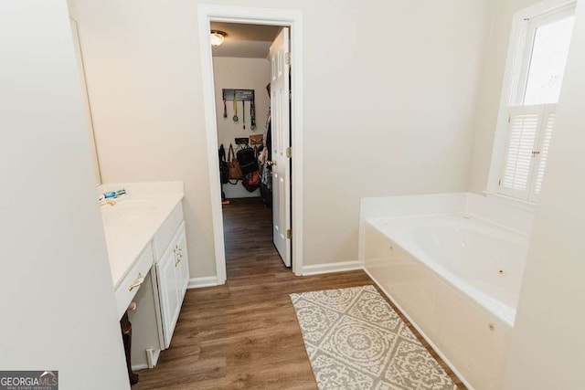 bathroom featuring hardwood / wood-style flooring, vanity, and a washtub