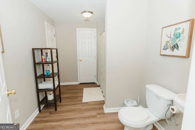 bathroom with hardwood / wood-style flooring and toilet