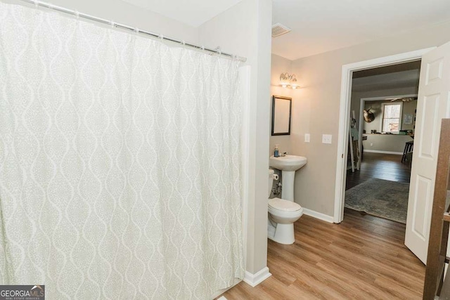 bathroom featuring hardwood / wood-style flooring, sink, and toilet