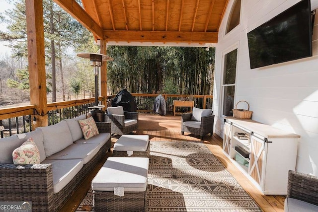 view of patio with a wooden deck and an outdoor living space