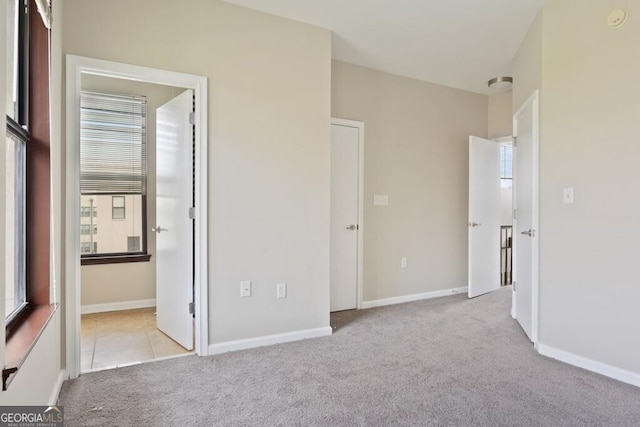 unfurnished bedroom featuring light carpet