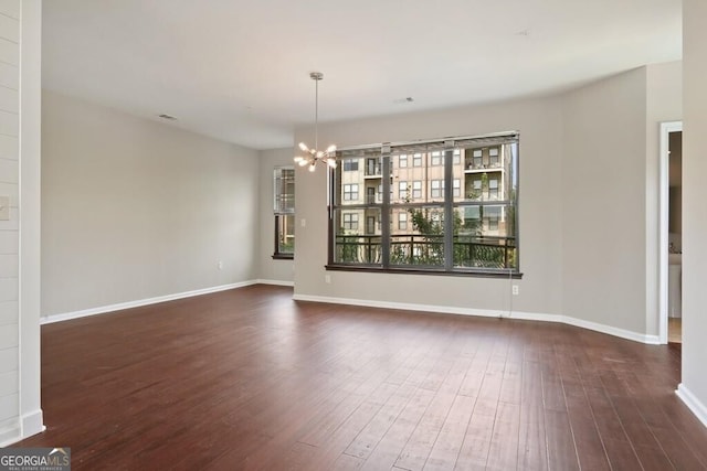 unfurnished dining area with dark wood-type flooring and a chandelier