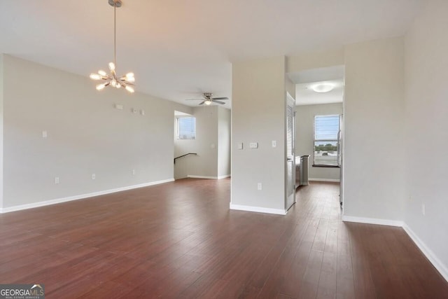 spare room with dark hardwood / wood-style floors and ceiling fan with notable chandelier