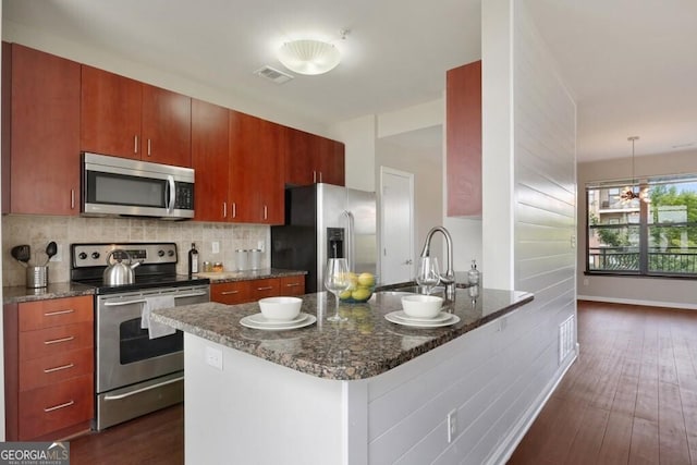 kitchen with appliances with stainless steel finishes, dark hardwood / wood-style flooring, sink, and backsplash