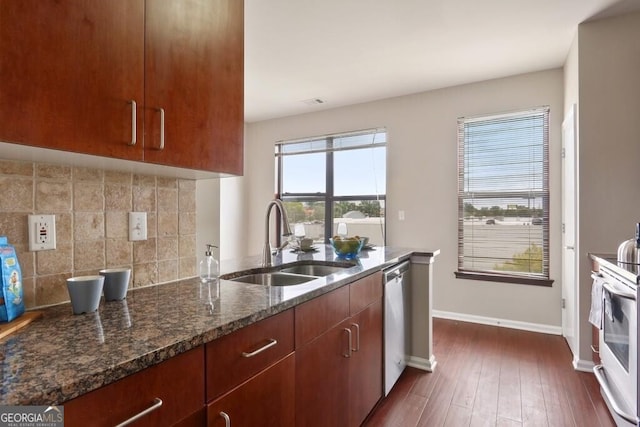 kitchen with dishwasher, sink, backsplash, dark hardwood / wood-style flooring, and dark stone counters