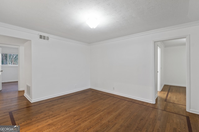 spare room featuring ornamental molding, dark hardwood / wood-style floors, and a textured ceiling