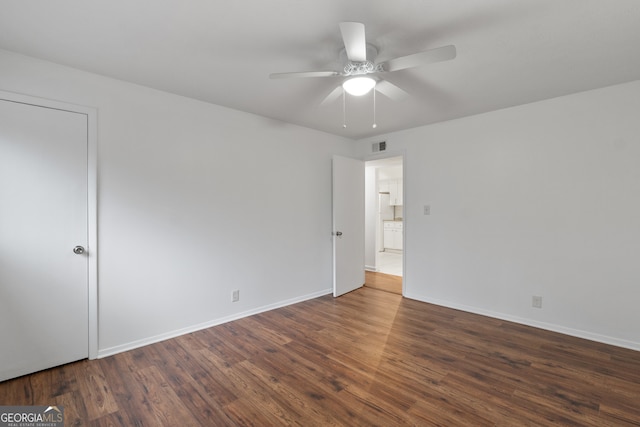 spare room featuring dark hardwood / wood-style flooring and ceiling fan