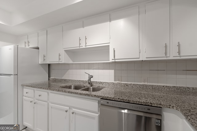 kitchen featuring sink, stainless steel dishwasher, white fridge, light stone countertops, and white cabinets