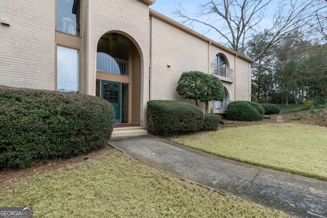 property entrance with a lawn