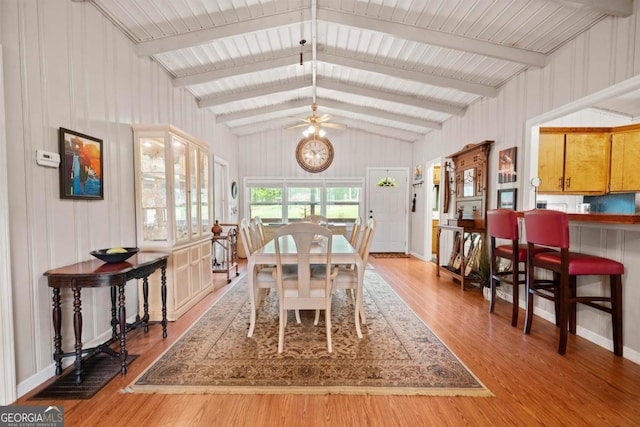 dining space with ceiling fan, lofted ceiling with beams, and light hardwood / wood-style flooring