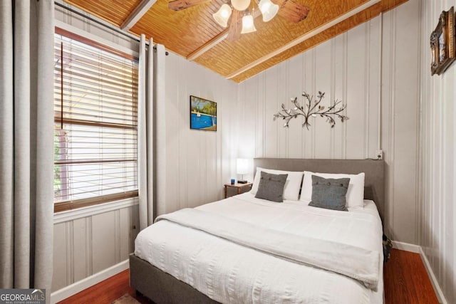 bedroom with lofted ceiling, dark hardwood / wood-style floors, wooden ceiling, and wooden walls