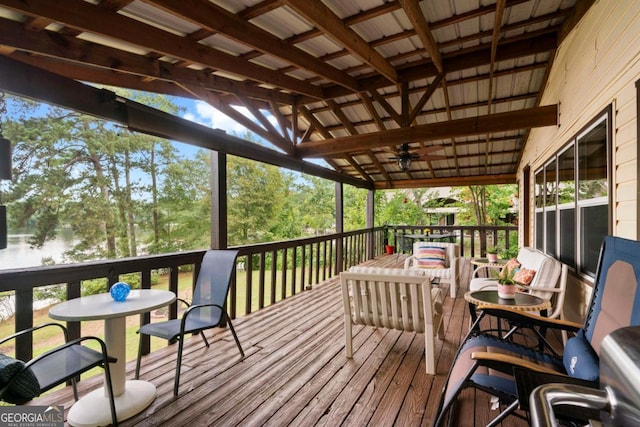 wooden deck with a water view and ceiling fan