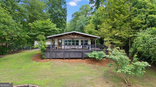 back of property featuring a wooden deck and a yard