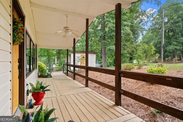 wooden terrace with a shed and ceiling fan