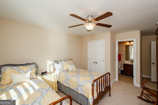 bedroom featuring light carpet, a closet, ceiling fan, and ensuite bathroom