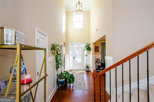 foyer with a high ceiling, crown molding, and dark hardwood / wood-style floors