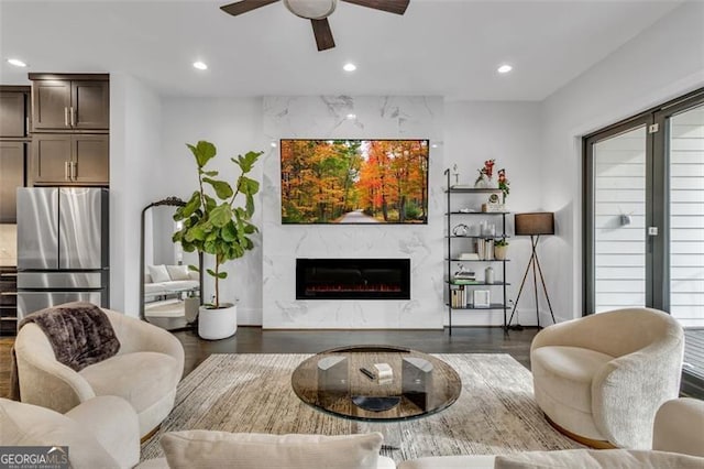 living room featuring dark hardwood / wood-style flooring, a fireplace, and ceiling fan