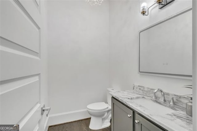 bathroom with wood-type flooring, toilet, and vanity