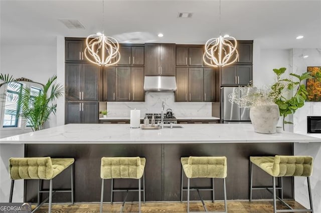 kitchen with pendant lighting, a kitchen bar, and a chandelier