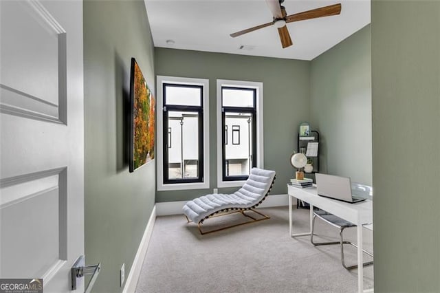 home office featuring light carpet and ceiling fan