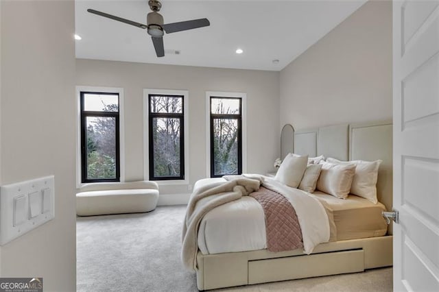 bedroom featuring light carpet, multiple windows, and ceiling fan