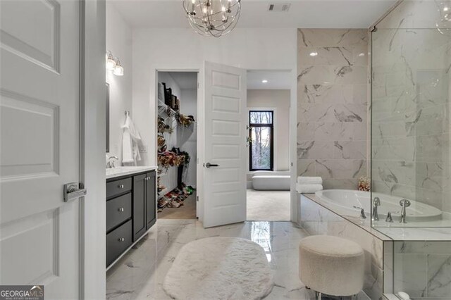 bathroom featuring vanity and tiled bath