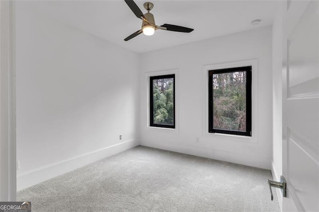 carpeted spare room featuring ceiling fan