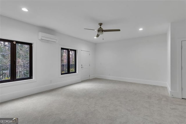 spare room featuring light colored carpet, an AC wall unit, and ceiling fan